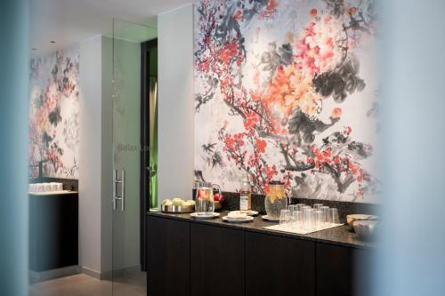 um quarto com um buffet com uma parede floral em Small & Beautiful Hotel Gnaid em Tirolo