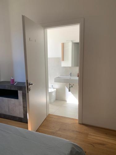 ein Bad mit einem Waschbecken und einer Tür zu einem Zimmer in der Unterkunft La Lanterna sul mare in Livorno