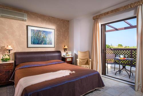 a hotel room with a bed and a balcony at Hersonissos Maris in Hersonissos