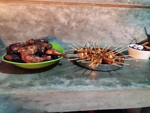 two skewers of food are cooking on a grill at Ella green stay in Ella