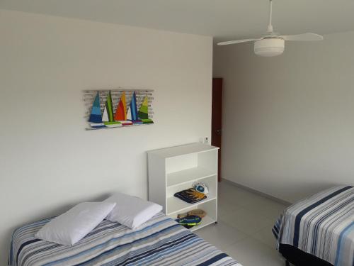 1 dormitorio con 2 camas y una pintura de veleros en la pared en Praia do Sonho, en Palhoça