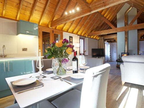 a dining room with a white table with flowers on it at The Barn At Banks Cottage in Pulborough