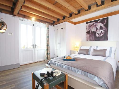 a bedroom with a large bed with a painting on the wall at The Barn At Banks Cottage in Pulborough