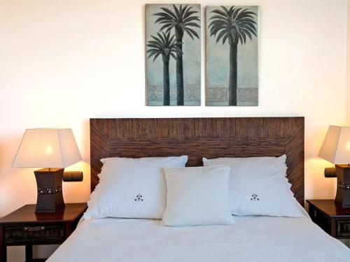 a bedroom with a bed with two lamps and two palm trees at Holiday Home Villa Gema, spacious, scenic, Wlan ,AC in Maspalomas