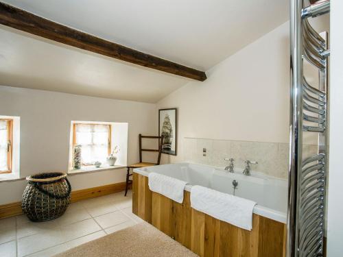 baño grande con bañera y ventana en Castle House Cottage, en Kirkby Stephen