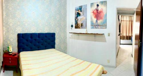 a bedroom with a bed with a blue head board at CABO FRIO - Praia do Forte lindo e aconchegante in Cabo Frio