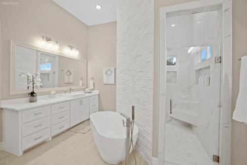 a white bathroom with a toilet and a shower at Newly Built Stylish Retreat with Designer Kitchen - Near Park & Beach in Corpus Christi