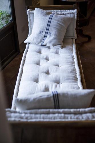 a bed with white sheets and pillows on it at Villino di Porporano in Parma