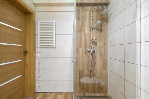 a shower with a glass door in a bathroom at DOMKI TU I TERAZ in Szczawnica