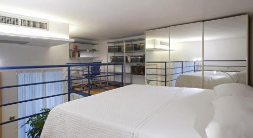 ナポリにあるCasa Vittoriaのベッドルーム(白いベッド1台、一部の棚付)