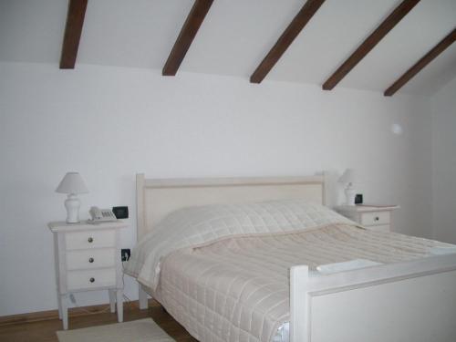 a bedroom with a white bed and two night stands at Pensiunea Funivia in Săcele