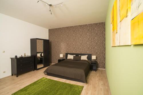 a bedroom with a bed and a green rug at Rumbach Holiday in Budapest