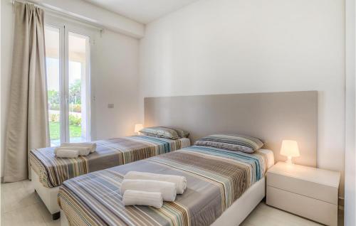 2 letti in una camera bianca con finestra di Gorgeous Home In Santa Croce Camerina With Swimming Pool a Santa Croce Camerina