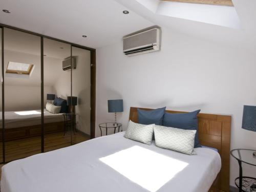 una camera da letto con un grande letto bianco con cuscini blu di Casa em Lisboa a Lisbona