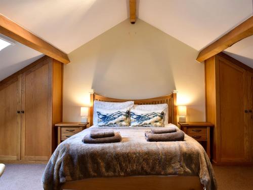 una camera con un letto con due cuscini sopra di Hilltoft Barn a Dockray