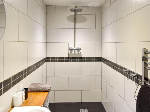 ein Bad mit weiß gefliesten Wänden und einem Waschbecken in der Unterkunft Hilltoft Barn in Dockray