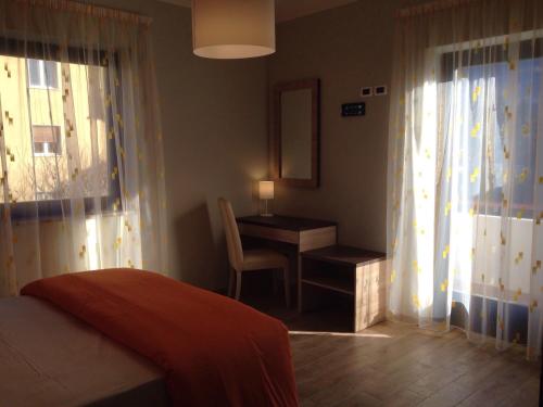 a bedroom with a bed and a desk and a window at Garni Villa Betty in Merano