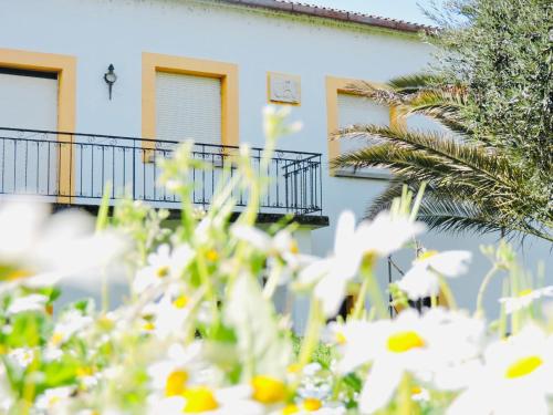 a building with white flowers in front of it at Nogueira Country House in Fundão
