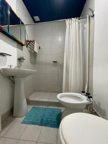 ein Bad mit einem Waschbecken, einem WC und einer Dusche in der Unterkunft Lipi House Hostel in Capilla del Monte