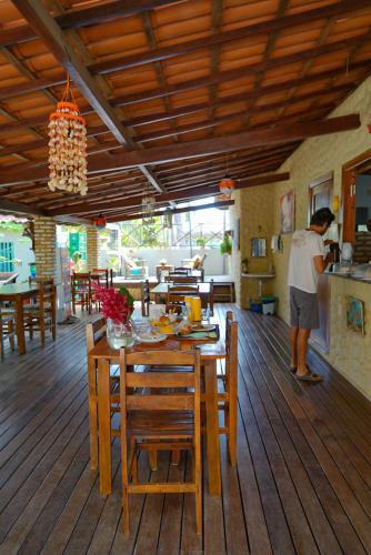 a man in a kitchen with a table and chairs at Casa do velejador in Barra Grande