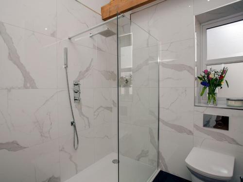 a bathroom with a glass shower with a toilet at Brens Barn in Bedale
