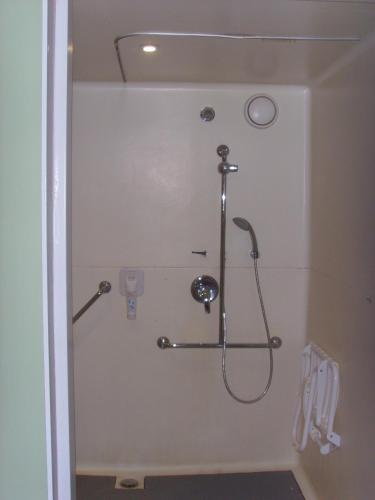 a shower stall in a bathroom with a shower at ibis budget L'Isle Adam in LʼIsle-Adam