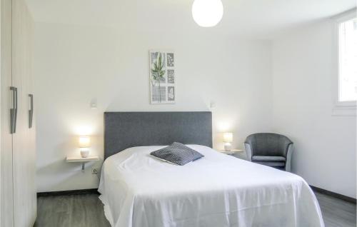 una camera bianca con un letto e una sedia di Gorgeous Apartment In Pirou With Kitchen a Pirou