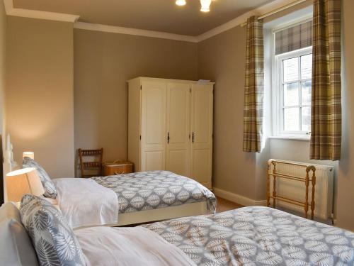 a bedroom with two beds and a window at Hallams Yard in Skipton