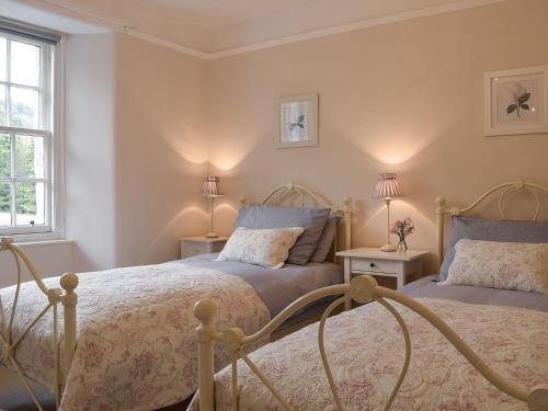 1 Schlafzimmer mit 2 Betten und 2 Lampen in der Unterkunft Ardchoille Cottage in Fortingall