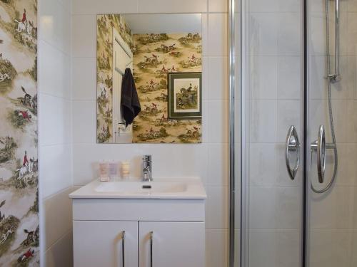 ein Bad mit einem Waschbecken und einer Dusche in der Unterkunft Ardchoille Cottage in Fortingall