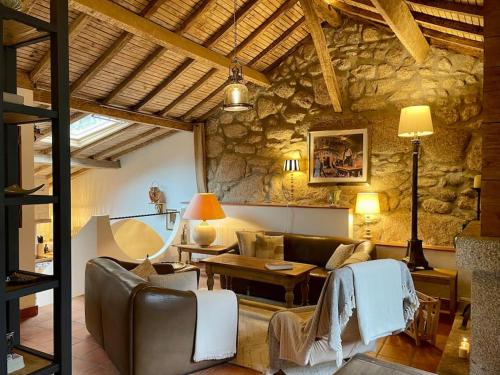 a large living room with a stone wall at Cottage da Minha Terra 1890 près d'un lac in Geres