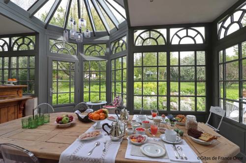 un comedor con una mesa con comida. en La Gentilhommière de Moulins, en Moulins-sur-Orne