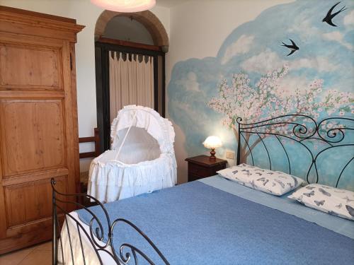 a bedroom with a blue bed and a painting on the wall at Nido di Rondine in Montespertoli