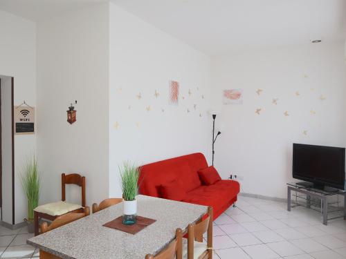 a living room with a red couch and a table at Relax&Natura a 6 minuti da BRESCIA Wifi a Rezzato in Rezzato