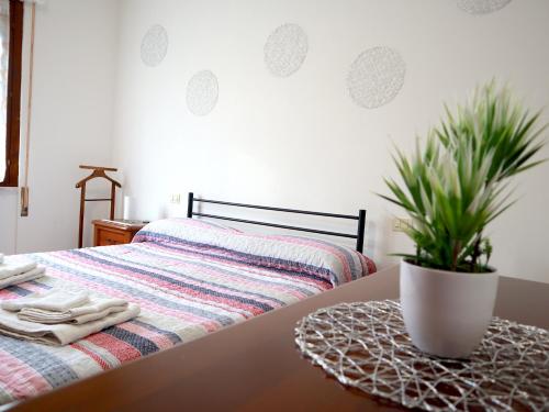 un letto con un tavolo con una pianta in vaso di [Relax&Natura] a 5 minuti da BRESCIA Wifi+ Netflix a Rezzato
