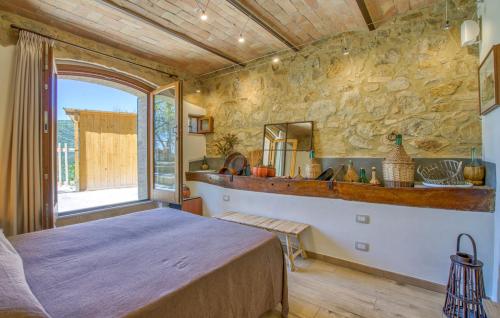 a bedroom with a bed and a stone wall at Casa Maria - Dimora di Charme in Montalcino