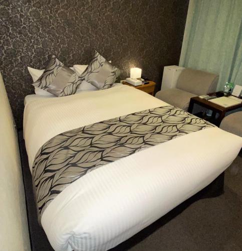 a bedroom with a bed with a white comforter at Roppongi Plaza Hotel in Tokyo