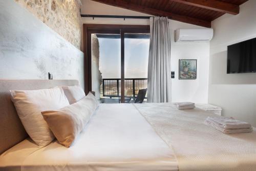 a bedroom with a large bed with a large window at Ali Vafi's Villa - Heated Jacuzzi & Indoor Pool in Maroulás