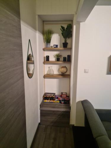 a hallway with a couch and a mirror and shelves at Logement entier situé à Taponnat Fleurignac. in Taponnat-Fleurignac