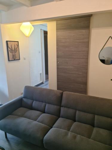 a living room with a couch and a wooden door at Logement entier situé à Taponnat Fleurignac. in Taponnat-Fleurignac