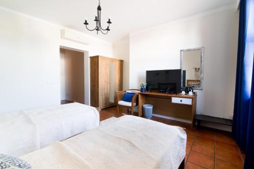 a bedroom with two beds and a desk with a television at HOTEL LEMONIADA in Lućmierz