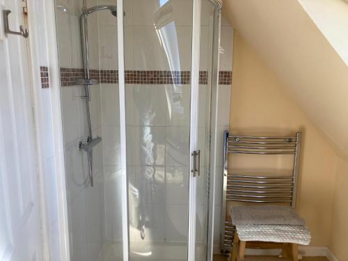 a bathroom with a shower and a chair in a room at Plockton, Camus Fearn Barn in Plockton