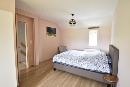 Schlafzimmer mit einem Bett und einem Fenster in der Unterkunft Gîte Jod'en Campagne in Vaux-sur-Sûre