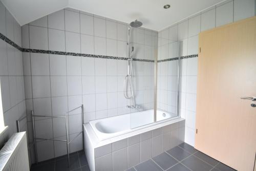 ein weißes Bad mit einer Badewanne und einer Dusche in der Unterkunft Gîte Jod'en Campagne in Vaux-sur-Sûre