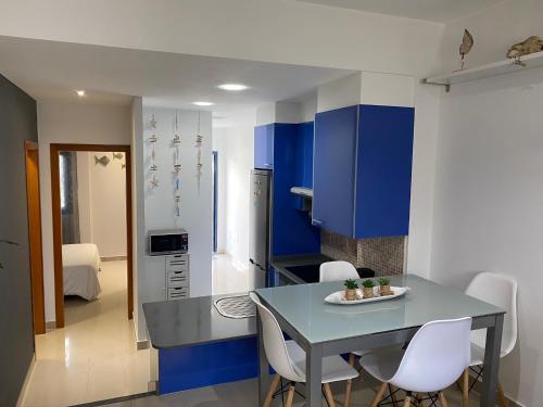 a kitchen with blue cabinets and a table and chairs at Oasis Cotillo in Cotillo