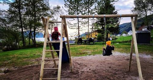 two children playing on a swing in a park at Sognhostel in Sørbø