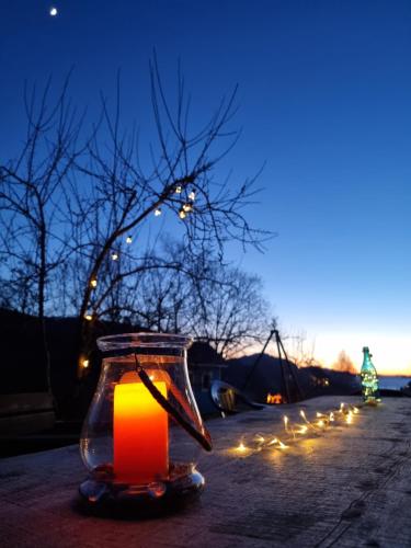 a lit candle in a glass jar with lights at Sognhostel in Sørbø