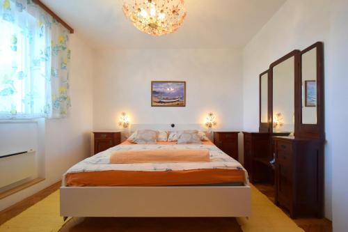 a bedroom with a bed and a chandelier at Apartment Angela in Malinska