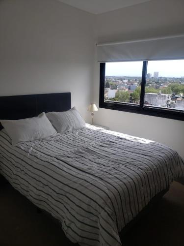1 dormitorio con 1 cama grande y ventana grande en Departamento cómodo, luminoso con excelente vista. en San Fernando