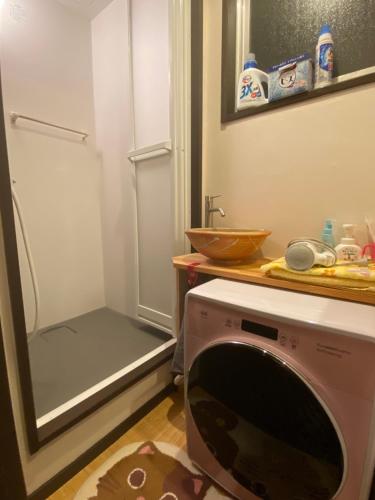 una lavadora en una cocina con fregadero en 澄心小筑.房东在住型民宿.雄琴车站免费接送, en Otsu